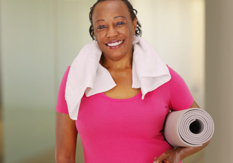 An elderly African American woman poses for a portrait after her workout